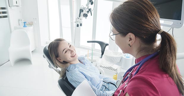 An experienced orthodontist treating a patient with Invisalign aligners.
