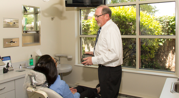 A dentist performs Invisalign alignment on a patient in Tinley Park, IL.